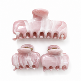 Set of pink marble hair clips on a white background