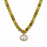 Necklace with green beads and a gold pendant on a white background