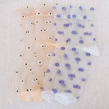 Set of two delicate sheer socks adorned with charming mini daisy patterns, offering a light and feminine touch to your everyday look.