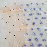 Set of two delicate sheer socks adorned with charming mini daisy patterns, offering a light and feminine touch to your everyday look.