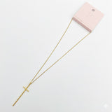 Delicate gold-tone necklace featuring a sleek vertical cross pendant on a fine chain, offering a modern and understated take on a classic faith-inspired design.