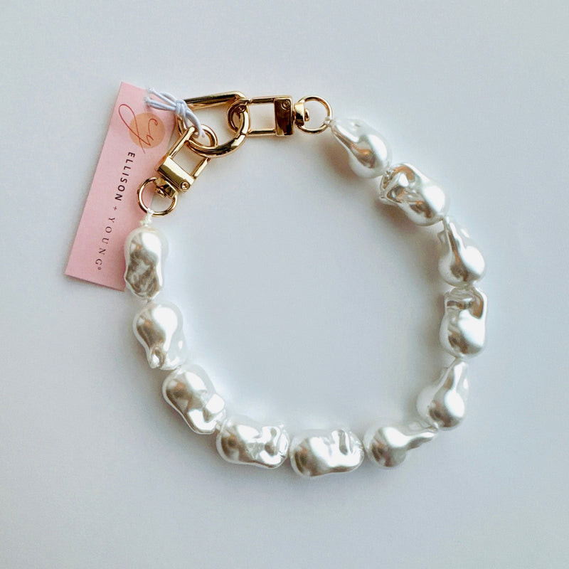 Modern phone lanyard with baroque pearls, showcasing their organic, irregular shapes and radiant luster, arranged in a single strand with a secure clasp attachment, ideal for adding elegance to tech accessories.