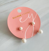 A pair of modern pearl earrings featuring a sleek gold-tone bar connecting two lustrous pearls—one smaller and one larger—for a minimalist yet elegant look. These dual pearl drop earrings combine classic sophistication with a modern silhouette.