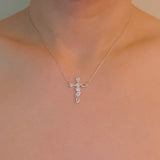 Silver cross pendant necklace featuring a mix of sparkling stone cuts in a modern design, suspended from a delicate chain.