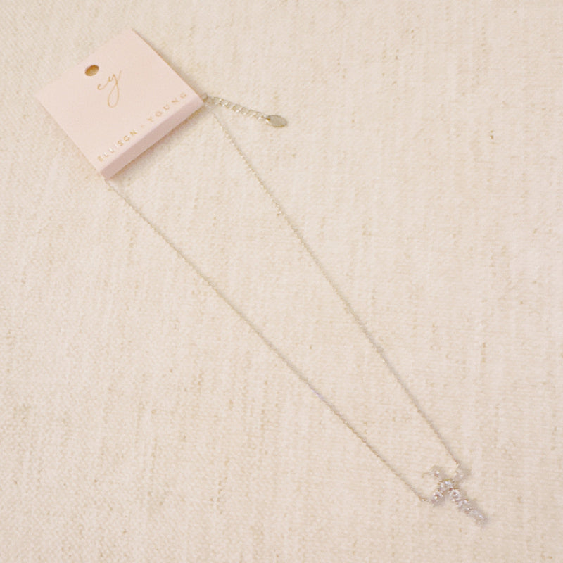 Silver cross pendant necklace featuring a mix of sparkling stone cuts in a modern design, suspended from a delicate chain.