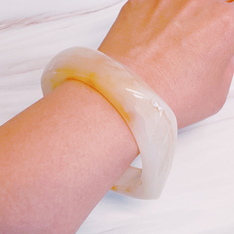 Chunky sculpted square bangle with a modern retro design, featuring a glossy finish and bold geometric shape.