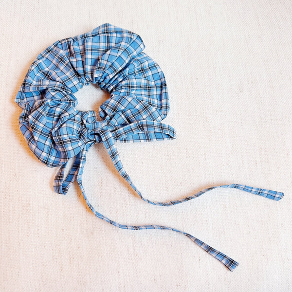 Stylish hair scrunchie featuring a classic plaid pattern with long, flowing tails—perfect for a polished, preppy look with a playful twist.