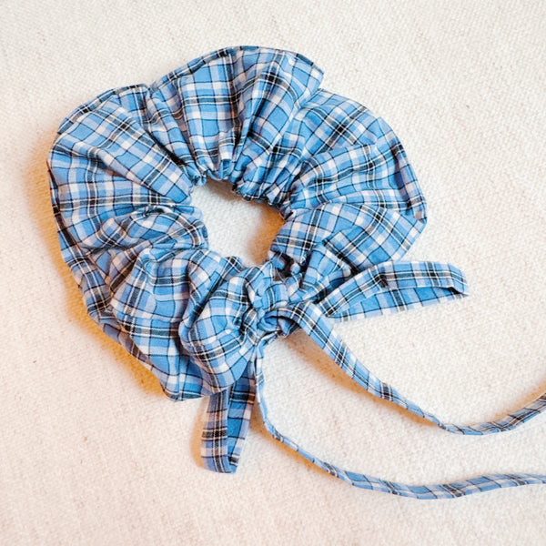 Stylish hair scrunchie featuring a classic plaid pattern with long, flowing tails—perfect for a polished, preppy look with a playful twist.