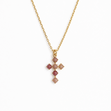 blush pink color stone bead cross pendant on gold chain. white background