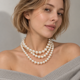 Model wearing the Noble Pearl 3-Piece Necklace Set layered together with an off-the-shoulder grey knit sweater