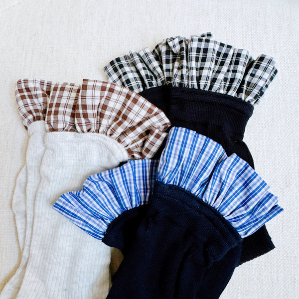Elegant plaid socks featuring delicate ruffle trim at the top—combining classic style with a chic, feminine twist.