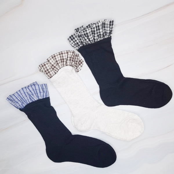 Elegant plaid socks featuring delicate ruffle trim at the top—combining classic style with a chic, feminine twist.