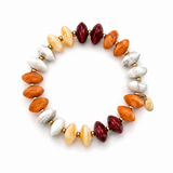 A beaded stretch bracelet featuring polished stone beads in orange, cream, white, and deep burgundy, separated by small gold spacer beads, with a small gold tag on the side, shown on a plain white background.