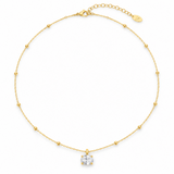 a necklace with oval cut diamond looking pendant with gold ball chain on white background