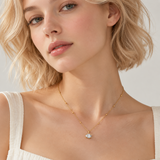 a woman wearing a necklace with oval cut diamond looking pendant with dainty gold ball chain necklace.