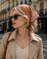 Woman wearing a headscarf and sunglasses on a city street