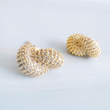 Pair of elegant interlocking loop earrings encrusted with shimmering pavé crystals. The design features two linked ovals forming a sculptural, modern silhouette with a refined, high-shine finish that catches the light beautifully.