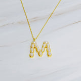 Gold chain necklace featuring an elegant initial pendant inlaid with pearl mosaic accents for a personalized, sophisticated touch.