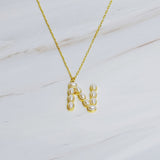 Gold chain necklace featuring an elegant initial pendant inlaid with pearl mosaic accents for a personalized, sophisticated touch.