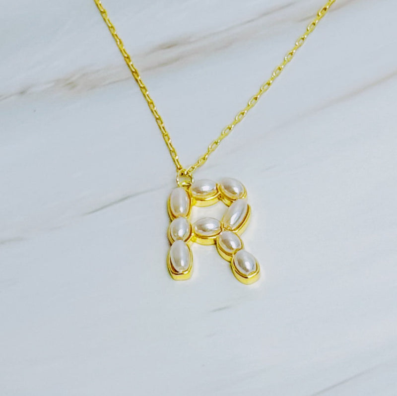 Gold chain necklace featuring an elegant initial pendant inlaid with pearl mosaic accents for a personalized, sophisticated touch.
