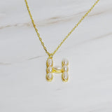 Gold chain necklace featuring an elegant initial pendant inlaid with pearl mosaic accents for a personalized, sophisticated touch.