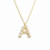 Gold necklace with a pendant shaped like the letter 'A' on a white background