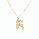 Gold necklaces with pearl beads on a initial pendant R with white background