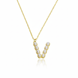 Gold necklace with a pendant  initial V featuring pearls on a white background