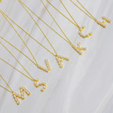 Gold chain necklace featuring an elegant initial pendant inlaid with pearl mosaic accents for a personalized, sophisticated touch.