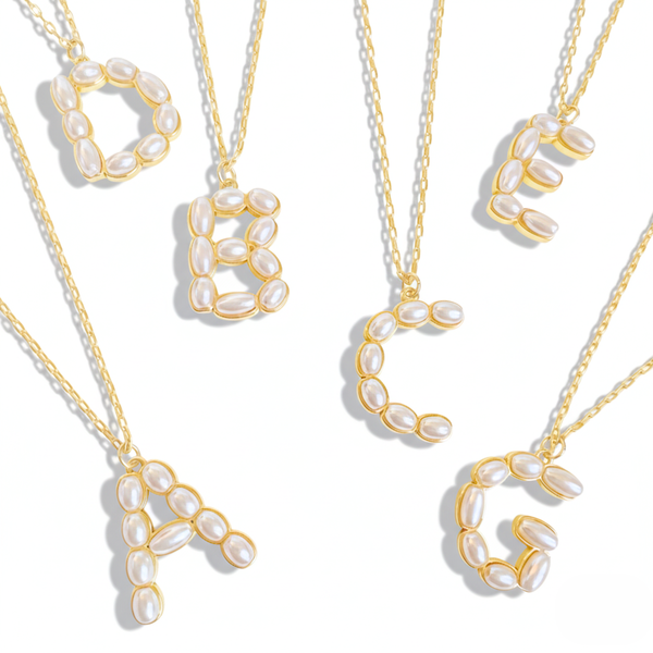 Gold necklaces with pearl-like beads on a white background