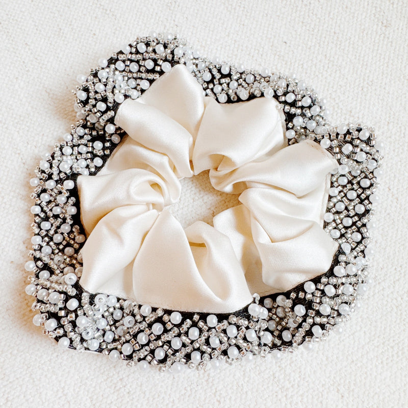  Elegant satin hair scrunchie embellished with delicate pearls and beads—adding a touch of sophistication and shine to any hairstyle.