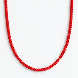 Close-up of a bold red beaded necklace featuring uniformly round, glossy beads strung together in a classic strand, creating a vibrant and timeless accessory.