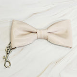 Beige bow tie with a metal clasp on a white background