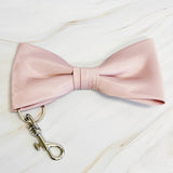 Pink bow tie with a metal clasp on a light background