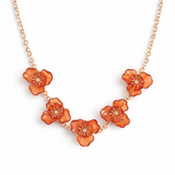 Necklace with orange floral pendants on a white background