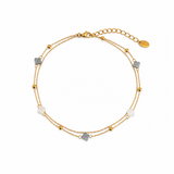 Delicate gold anklet featuring small clover-shaped charms with evenly spaced bead stations along a fine chain for a minimal, layered look.