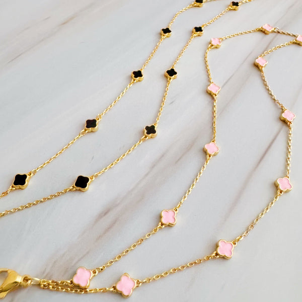 Delicate layered chain bracelet featuring a petite clover charm centerpiece, offering a minimalist and feminine touch with a refined gold-tone finish.
