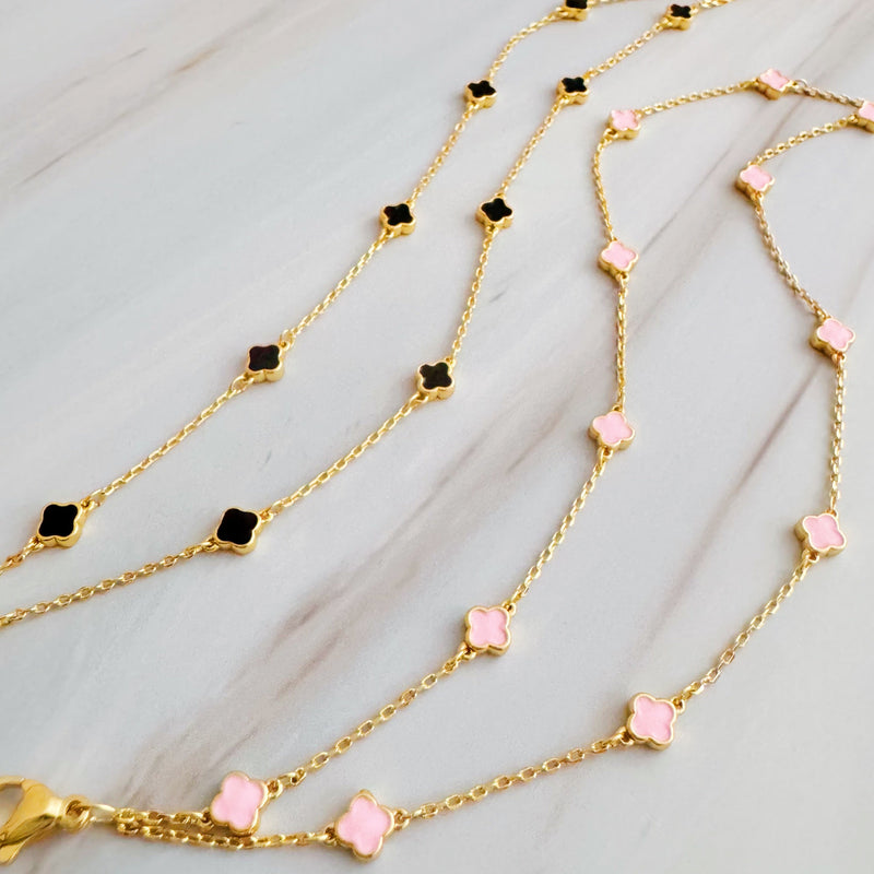 Delicate layered chain bracelet featuring a petite clover charm centerpiece, offering a minimalist and feminine touch with a refined gold-tone finish.