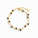 Delicate layered chain bracelet featuring a petite clover charm centerpiece, offering a minimalist and feminine touch with a refined gold-tone finish.