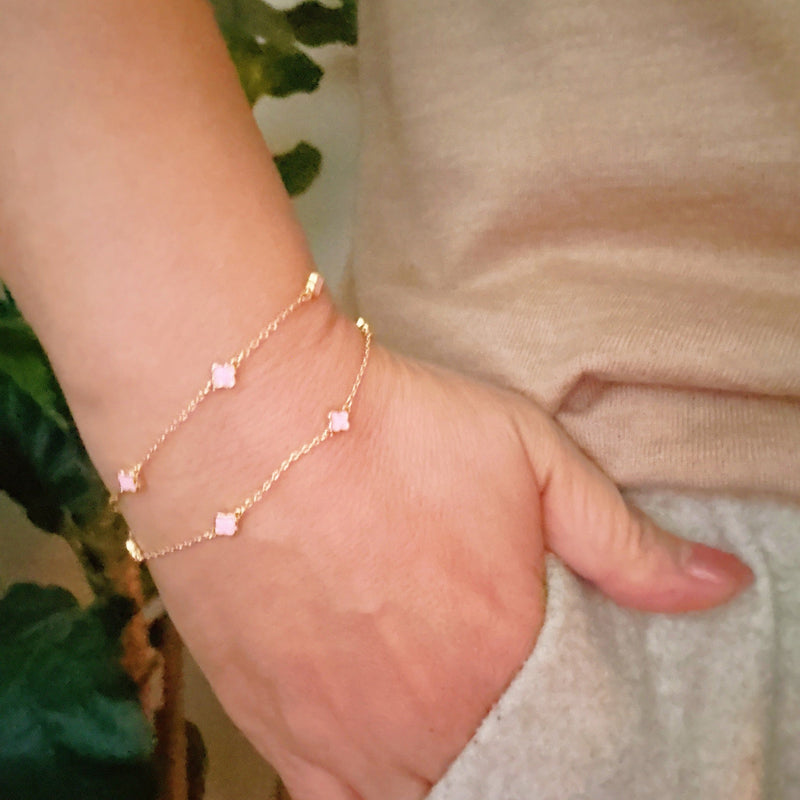 Delicate layered chain bracelet featuring a petite clover charm centerpiece, offering a minimalist and feminine touch with a refined gold-tone finish.