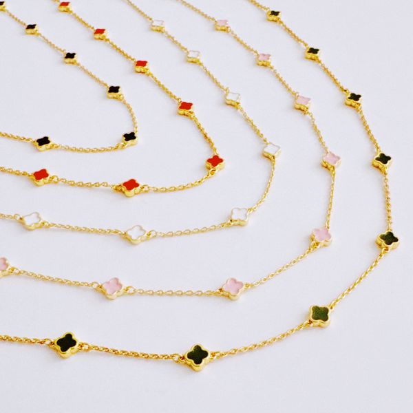 Gold-toned necklace featuring a delicate colored clover pendant, suspended on a fine chain for a soft pop of charm and color.