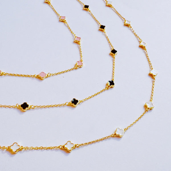 Gold-toned necklace featuring a delicate colored clover pendant, suspended on a fine chain for a soft pop of charm and color.