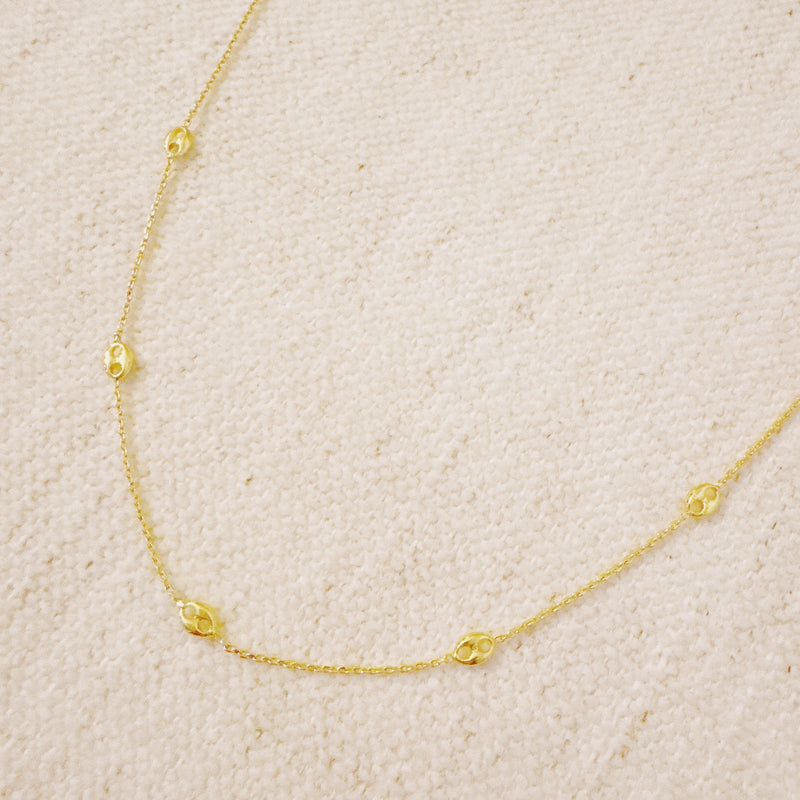 Delicate gold-tone necklace featuring evenly spaced petite chain links for a minimal and elegant look.