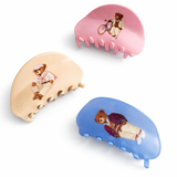 Three hair clips with bear illustrations on a white background
