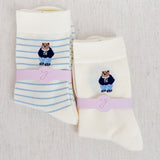 Set of cozy crew socks featuring charming preppy bear illustration in classic outfits, adding a playful and nostalgic touch to everyday wear.