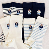 Set of cozy crew socks featuring charming preppy bear illustration in classic outfits, adding a playful and nostalgic touch to everyday wear.