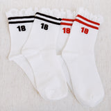 Set of two sporty crew socks featuring playful preppy details like ribbed texture and delicate lace trim at the cuff, blending athletic comfort with feminine charm.