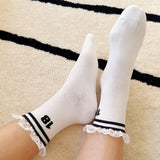 Set of two sporty crew socks featuring playful preppy details like ribbed texture and delicate lace trim at the cuff, blending athletic comfort with feminine charm.