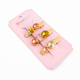 Set of colorful hair clips in a pink packaging on a white background