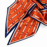 Orange scarf with white and blue pattern on a white background